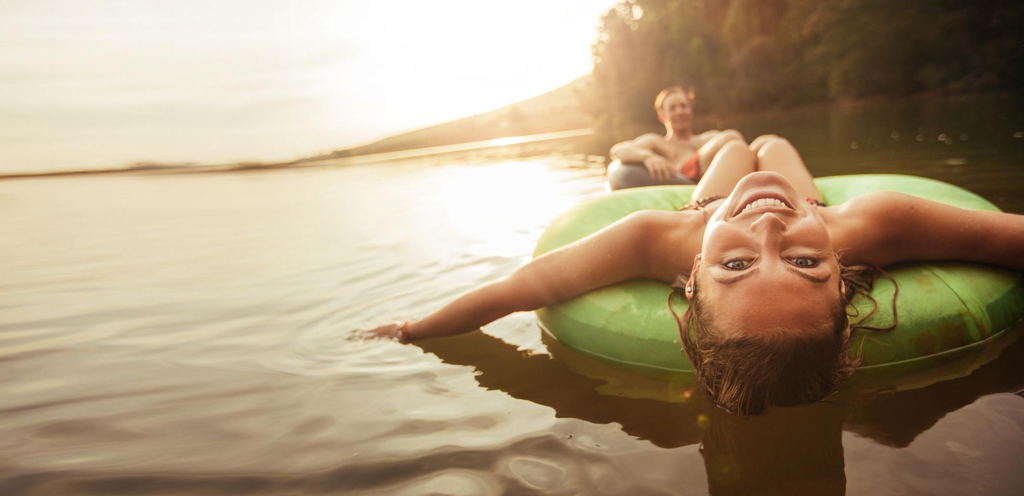 Young couple enjoying inflatable tubes outside on the water